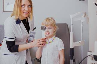 optometrist, Little girl checking her vision in doctors office in Concord, NC